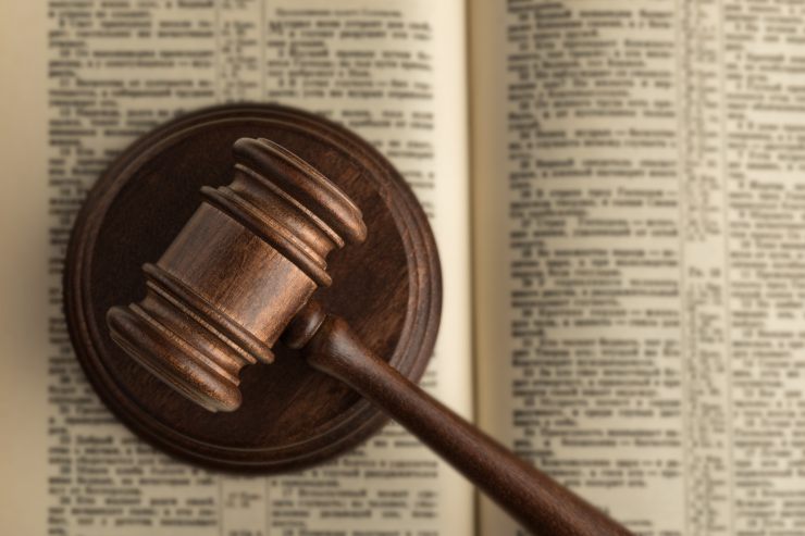 un libro di legge aperto con sopra un martello da giudice