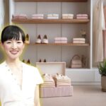 Marie Kondo in primo piano sorridente e sfondo di una cabina armadio ben in ordine