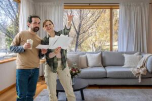 uomo e donna che guardano fogli su come arredaree e salotto sullo sfondo