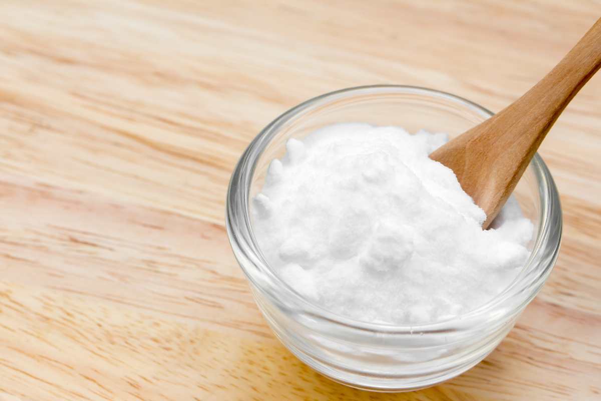 ciotola con bicarbonato ed un cucchiaio di legno 