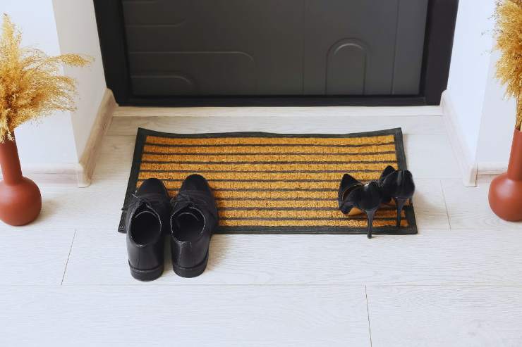 scarpe su tappeto di ingresso porta abitazione