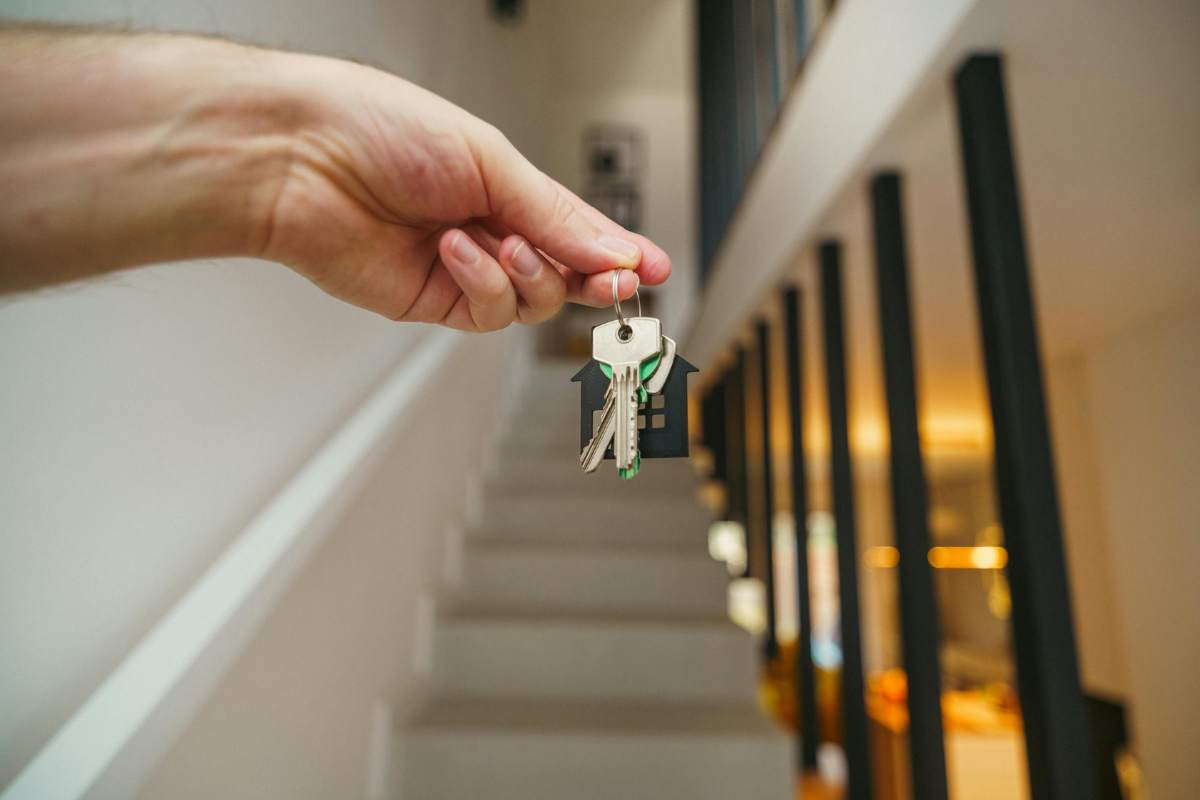 mani con chiavi e sfondo con delle scale 