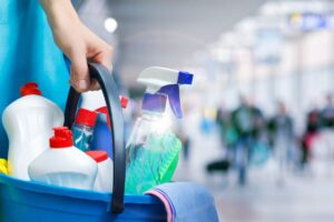 donna con secchio e all'interno prodotti per la pulizia
