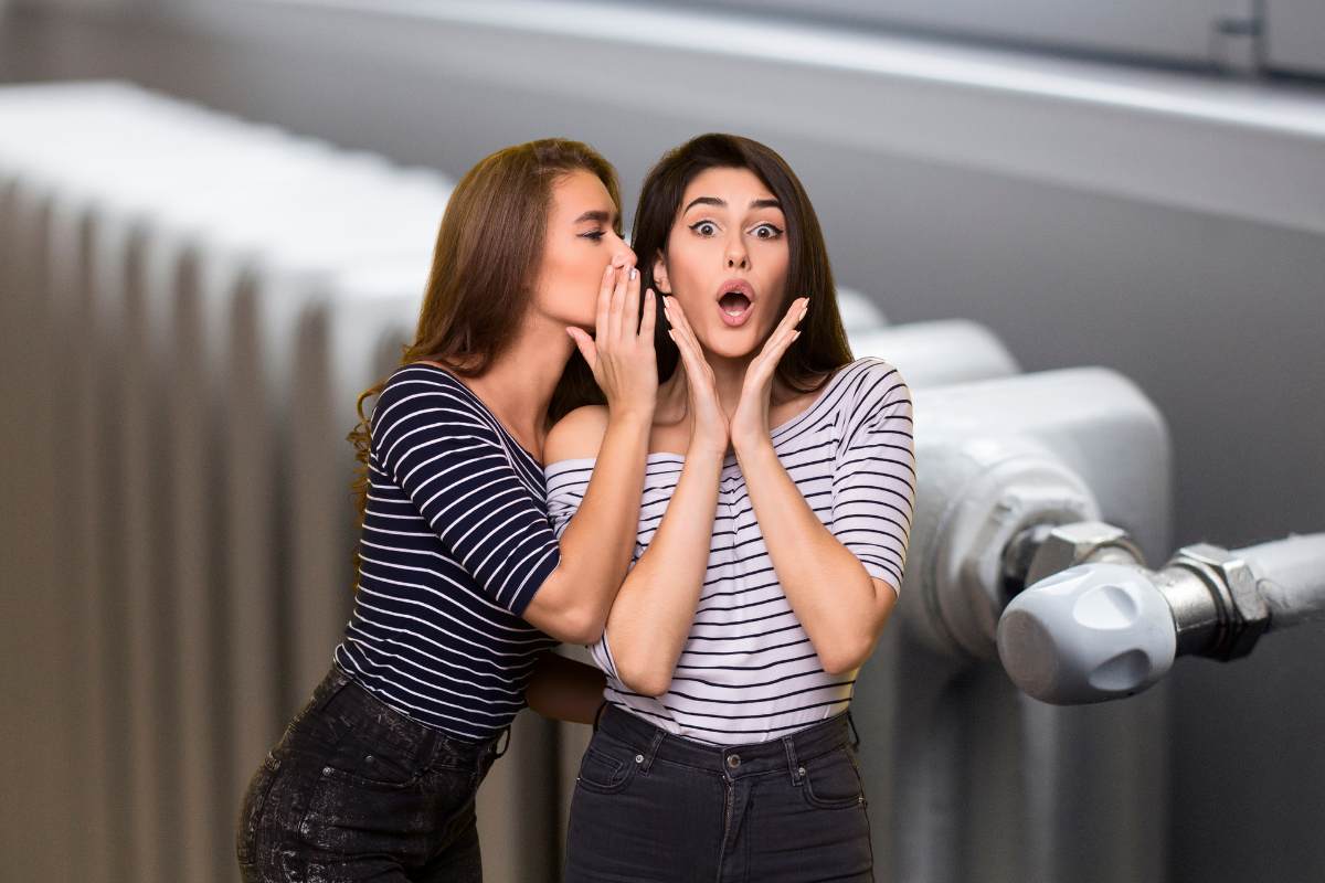 termosifone sullo sfondo e due donne che si parlano nell'orecchio