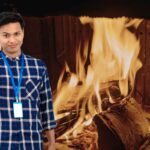 uomo con idea e dietro camino con legna che arde