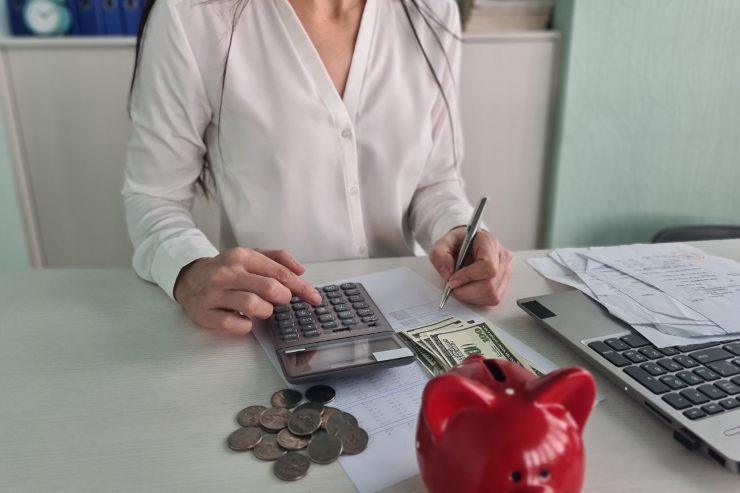 Un signora che fa i calcoli delle spese condominiali davanti ad un computer