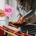 donna che stende panni in casa e mano con foglietto rosa e scritta no