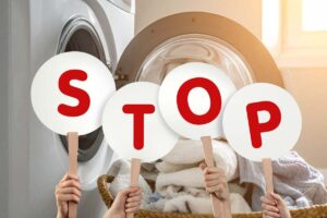 lavatrice aperta e scritta stop con cartelli