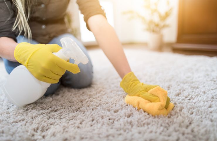 donna che pulisce tappeti