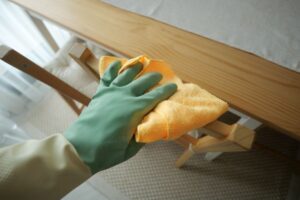 mano che impugna un panno per pulire un mobile in legno