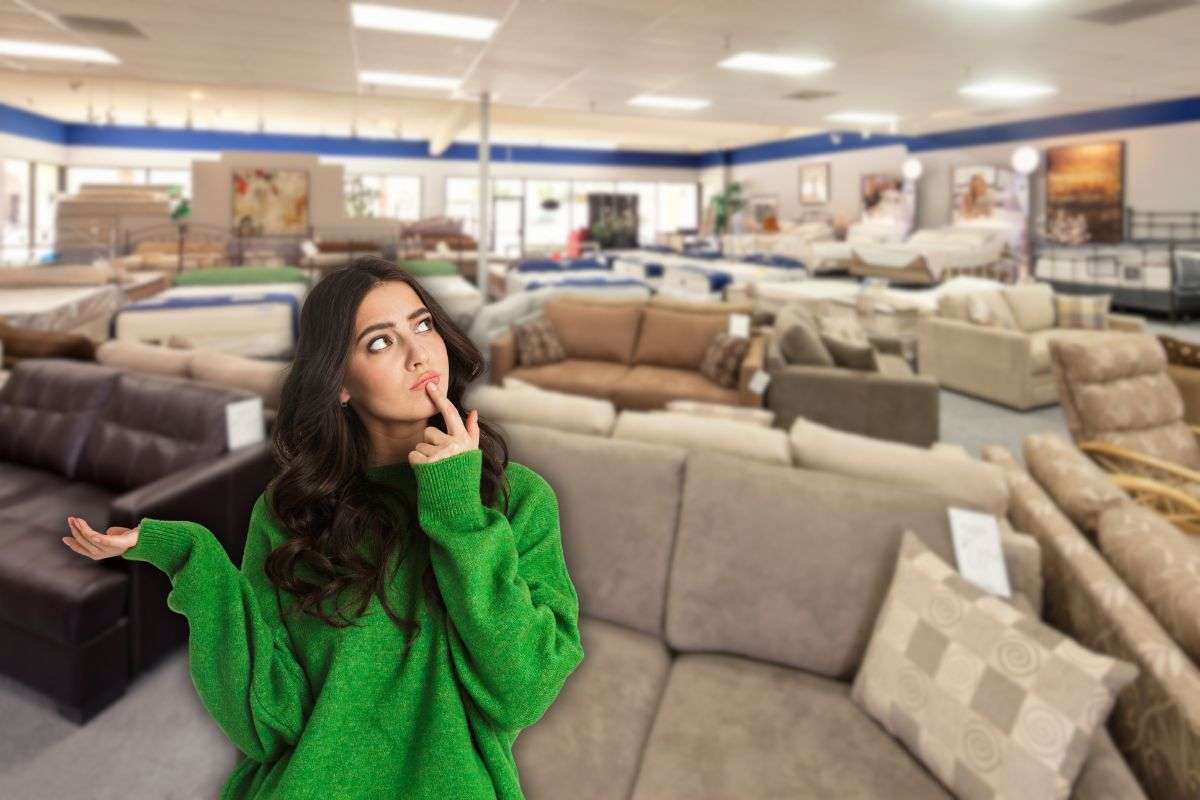 donna che pensa e che si trova all'interno di un negozio di divani