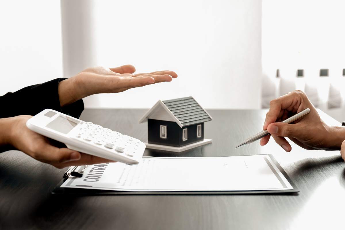 calcolatrice in mano e mano che firma foglio