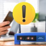 router wifi blu e mano con cellulare più simbolo rotondo per attenzione