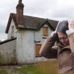 Una casa occupata ed una donna disperata in primo piano