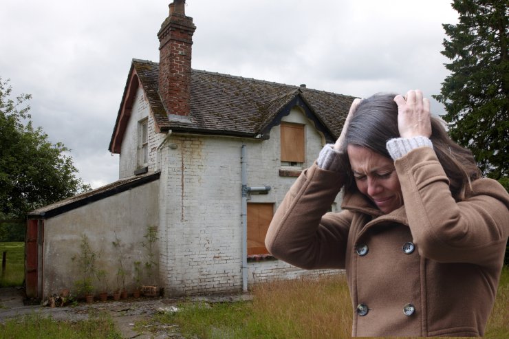 Una casa occupata ed una donna disperata in primo piano