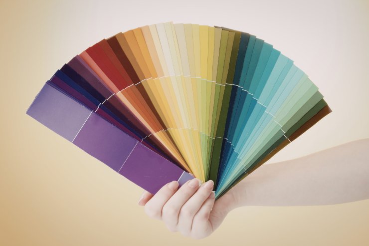 Una mano che tiene aperta a ventaglio una pallet di colori