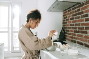 Una donna che cucina ma mantiene la cucina ordinata