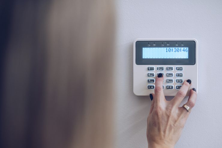 Una donna che sta impostando l'allarme di casa