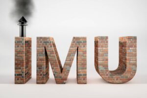 Una foto di una scritta IMU fatta in mattoni che presenta un comignolo sulla "I"