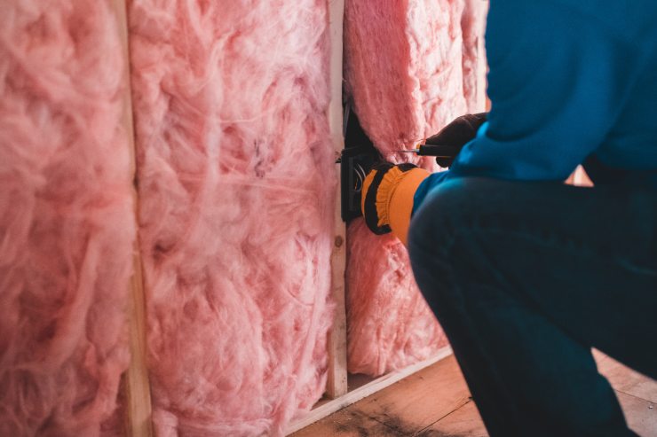 Un operaio che installa dell'isolante nelle pareti