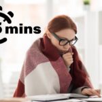 Una donna che lavora al computer a casa sua e che sente freddo e si copre con una coperta ed in alto a sinistra una grafica di un timer di 5 minuti