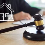 Un giudice con il suo martello ed una grafica di una casa in primo piano