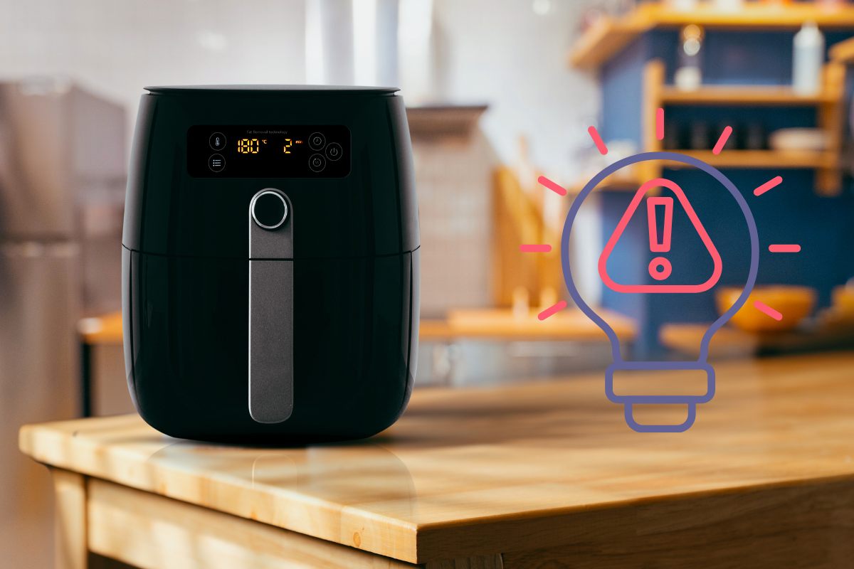 Una friggitrice con accanto una grafica di una lampadina con dentro un segnale di pericolo