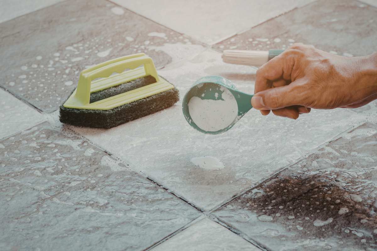 Una persona che pulisce le fughe del pavimento