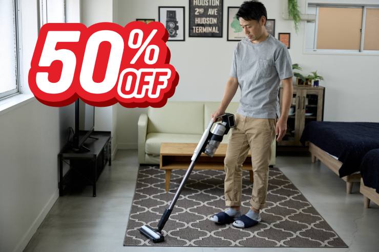 Un uomo che passa l'aspirapolvere in salone ed in alto a sinistra la scritta "50%off"