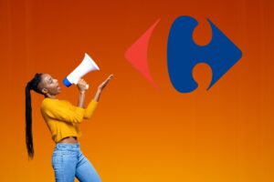 Una donna felice che con il megafono indica il simbolo del Carrefour