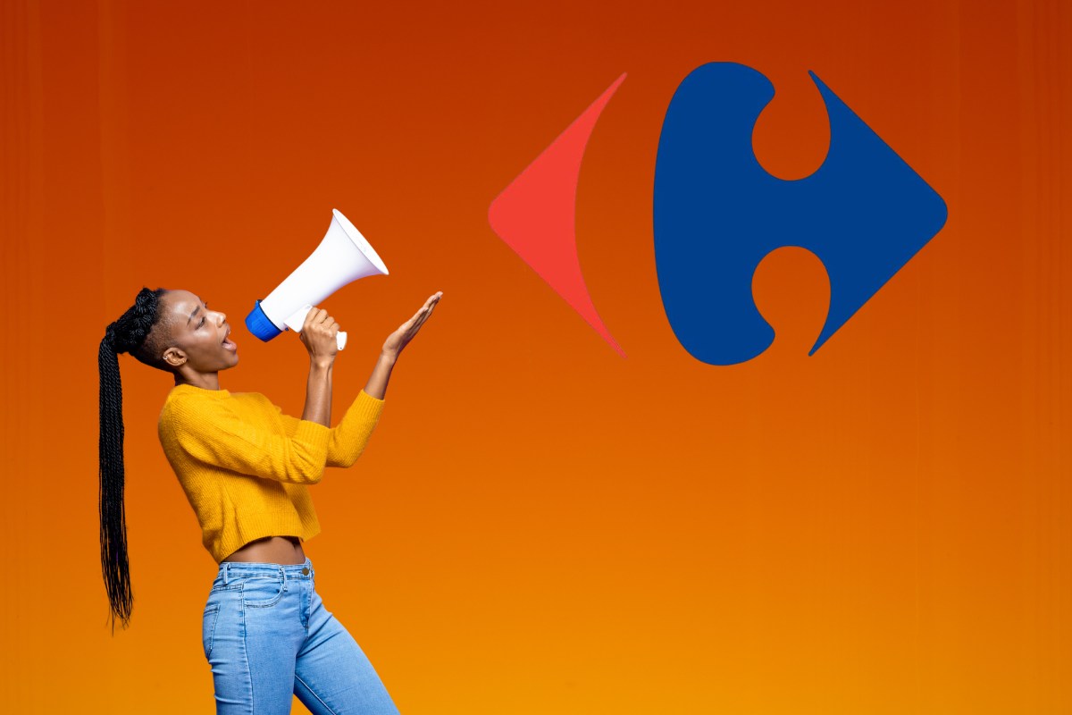 Una donna felice che con il megafono indica il simbolo del Carrefour