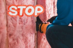 Un operaio che installa un cappotto termico e in alto a sinistra una scritta "Stop"