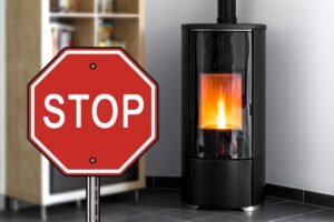 Una stufa a pellet in funzione e un segnale di stop sulla sinistra