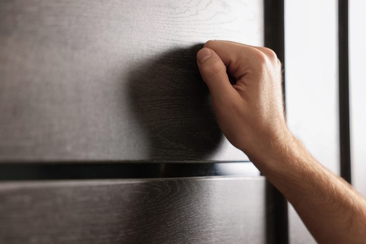 Un uomo che bussa ad una porta