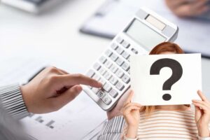 mano con calcolatrice e donna con cartello e punto interrogativo
