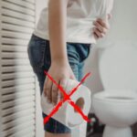 donna in bagno con carta igienica in mano