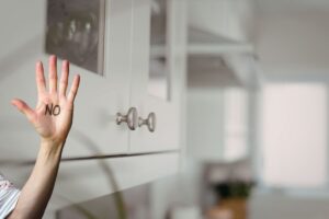 pensili da cucina e mano con scritta no sul palmo