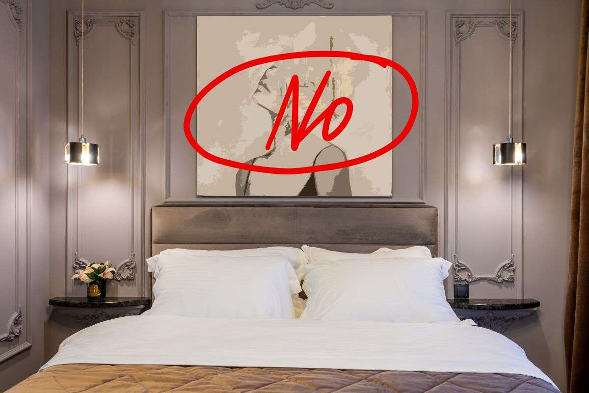 letto poggiato su una parete con un quadro e scritta no sopra
