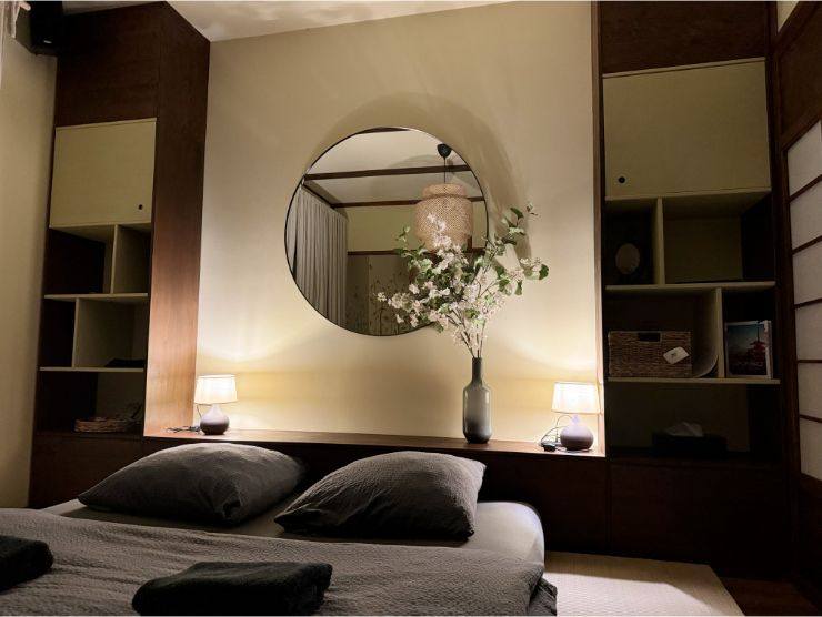 camera da letto in stile orientale con uno specchio sopra la testiera del letto