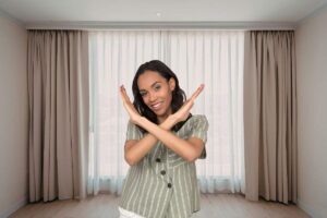 ampio soggiorno con tende alle finestre e donna che dice no