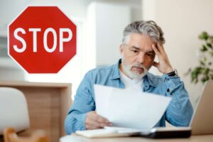 uomo preoccupato che legge bolletta e scritta stop