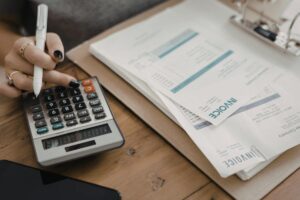 Una persona con davanti delle bollette e una calcolatrice