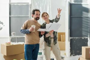 uomo e donna che discutono con cartina i lavori da fare in casa