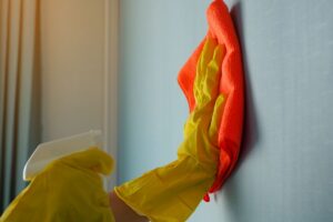 donna che pulisce muro blu