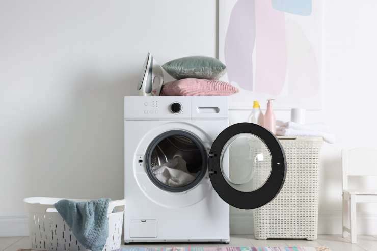 una lavatrice aperta con dentro dei panni
