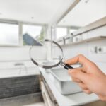 bagno sfocato e mano che tiene lente d'ingrandimento