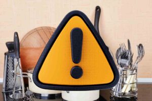 oggetti in cucina con cartello giallo e nero per l'attenzione