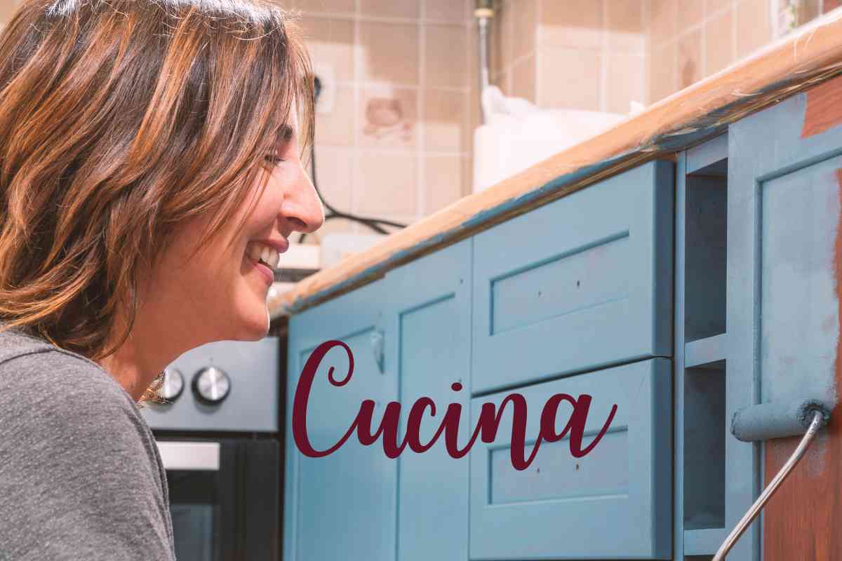 signora che con un rullo colora i pensili della cucina