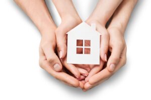 mani che stringono modellino di casa