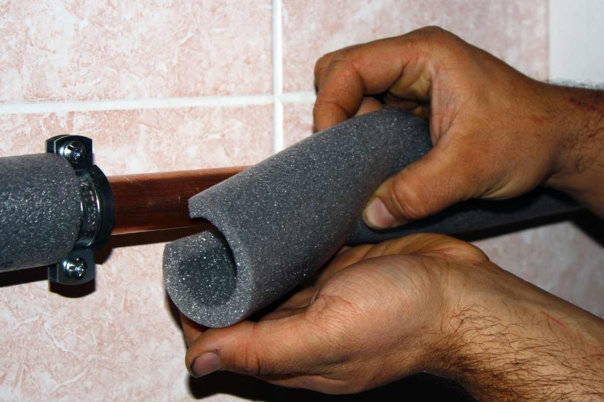 mano che mette protezione su di un tubo